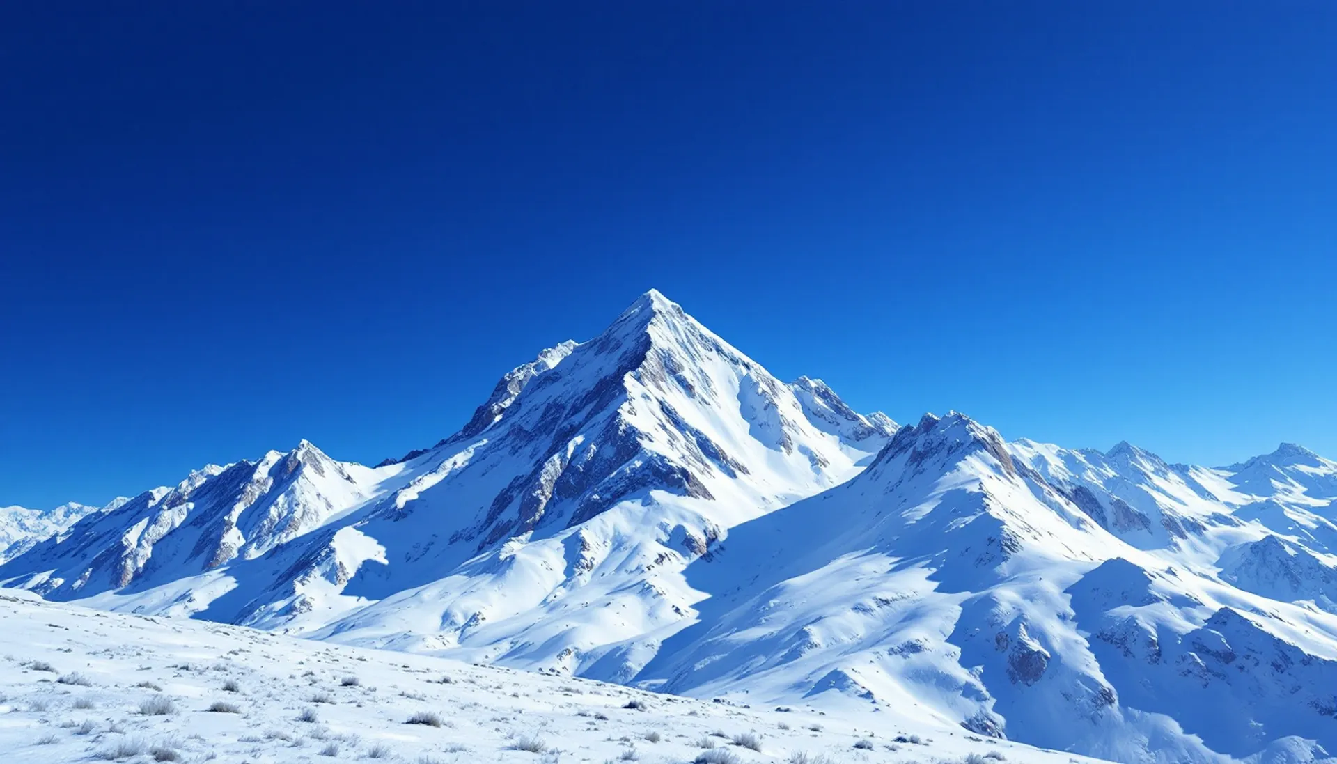 A long snow ridgeline under a deep blue sky